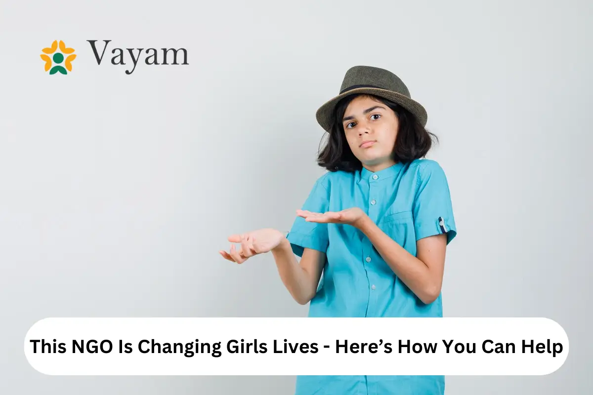 A young girl in a hat and blue shirt holds an item, symbolizing empowerment through the NGO's initiatives for girls.