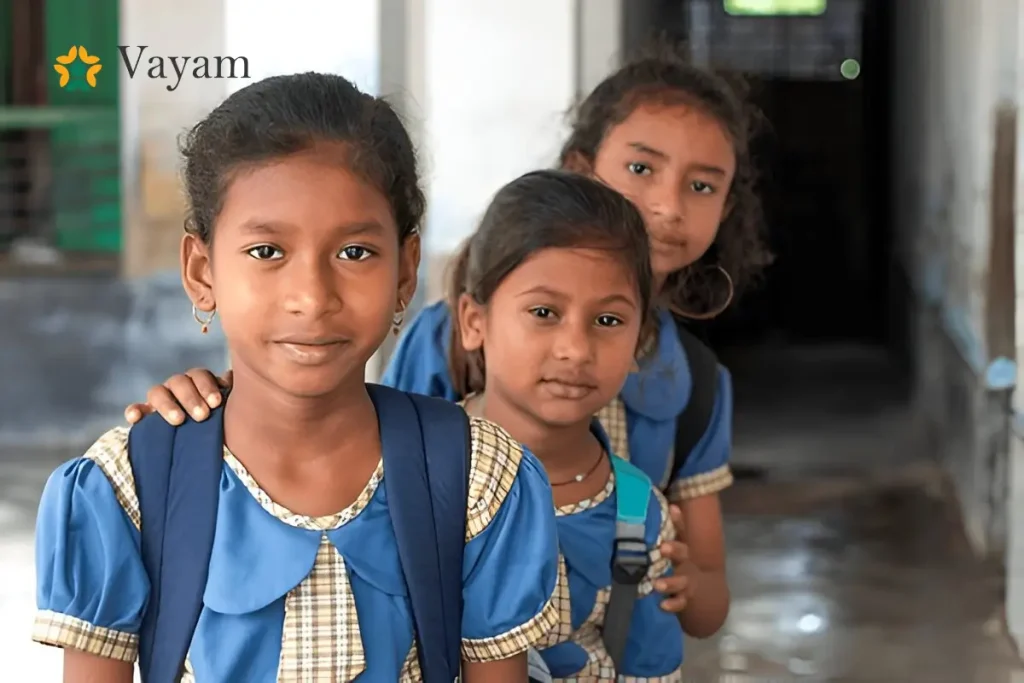 Three school uniformed girls stand in a hallway and embodying the mission of NGOs fighting for girls' rights and education.