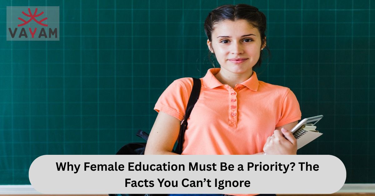 A college-going female, standing in front a green board in a classroom.