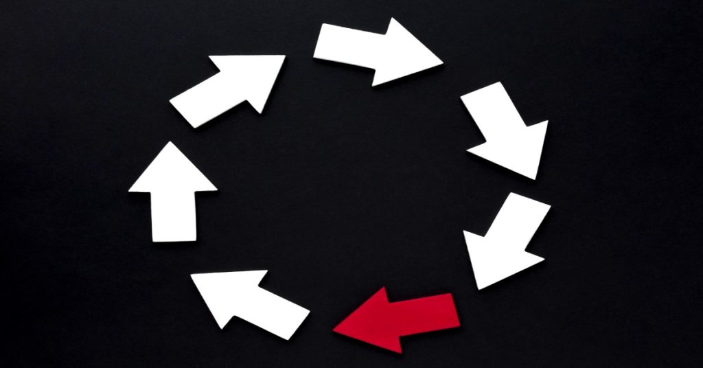 A circle of arrows with a red arrow pointing right, symbolizing the vicious cycle of exploitation in human trafficking.