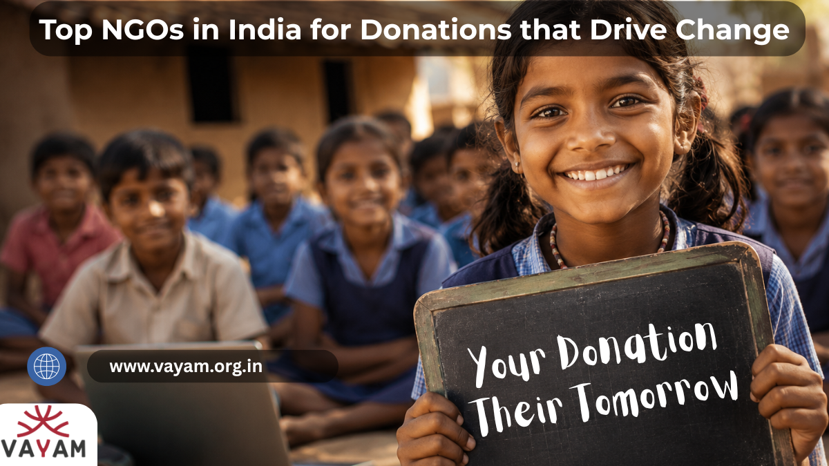 A smiling girl holds a chalkboard reading "Your Donation, Their Tomorrow" in front of a group of children in school uniforms, promoting Vayam Top NGOs in India for Donations that Drive Change